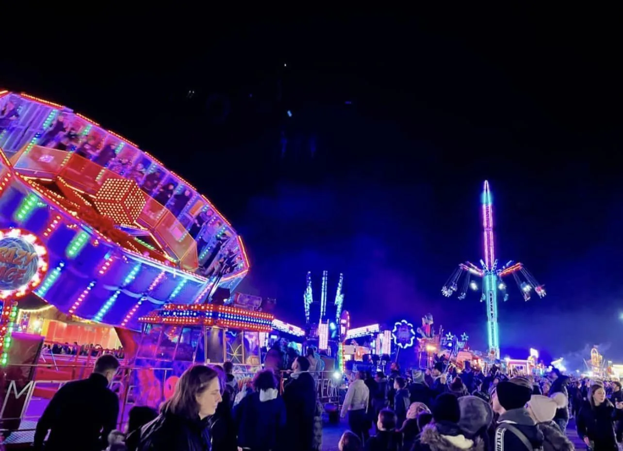 Bright fairground rides and attractions at night